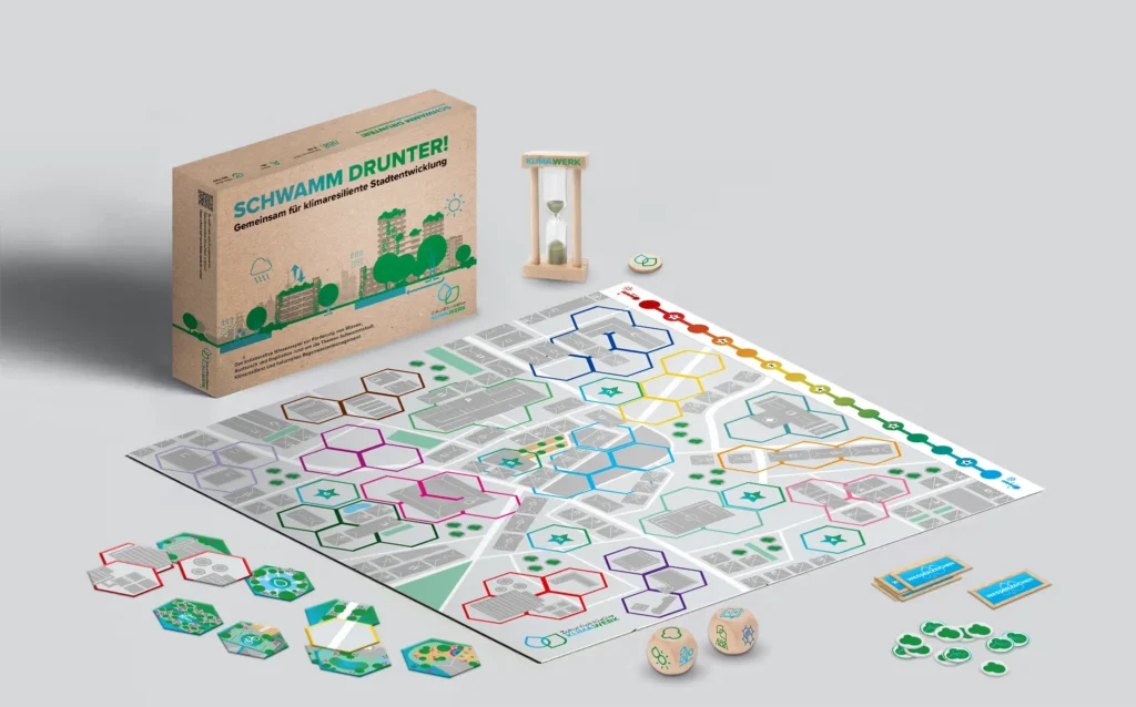 Ansicht des Spiels die Schwammstadt mit Karton, Sanduhr, Spielplan und Plättchen