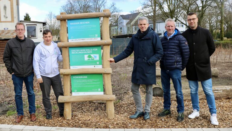 Gruppe von Beiteilten um eine Stehle des Wasser-Zeichens:(v.li.): Stefan Frackowiak (Abteilungsleiter Klima, Umwelt, Nachhaltigkeit und Stadtgrün bei der Stadt RE), Andreas Giga, (Leiter der Serviceorganisation der Zukunftsinitiative Klima.Werk bei Emschergenossenschaft/Lippeverband), Dezernent Axel Fritz, Michael Godde (Straßenbau Stadt RE) und Klimaanpassungsmanager Felix Sprenger.