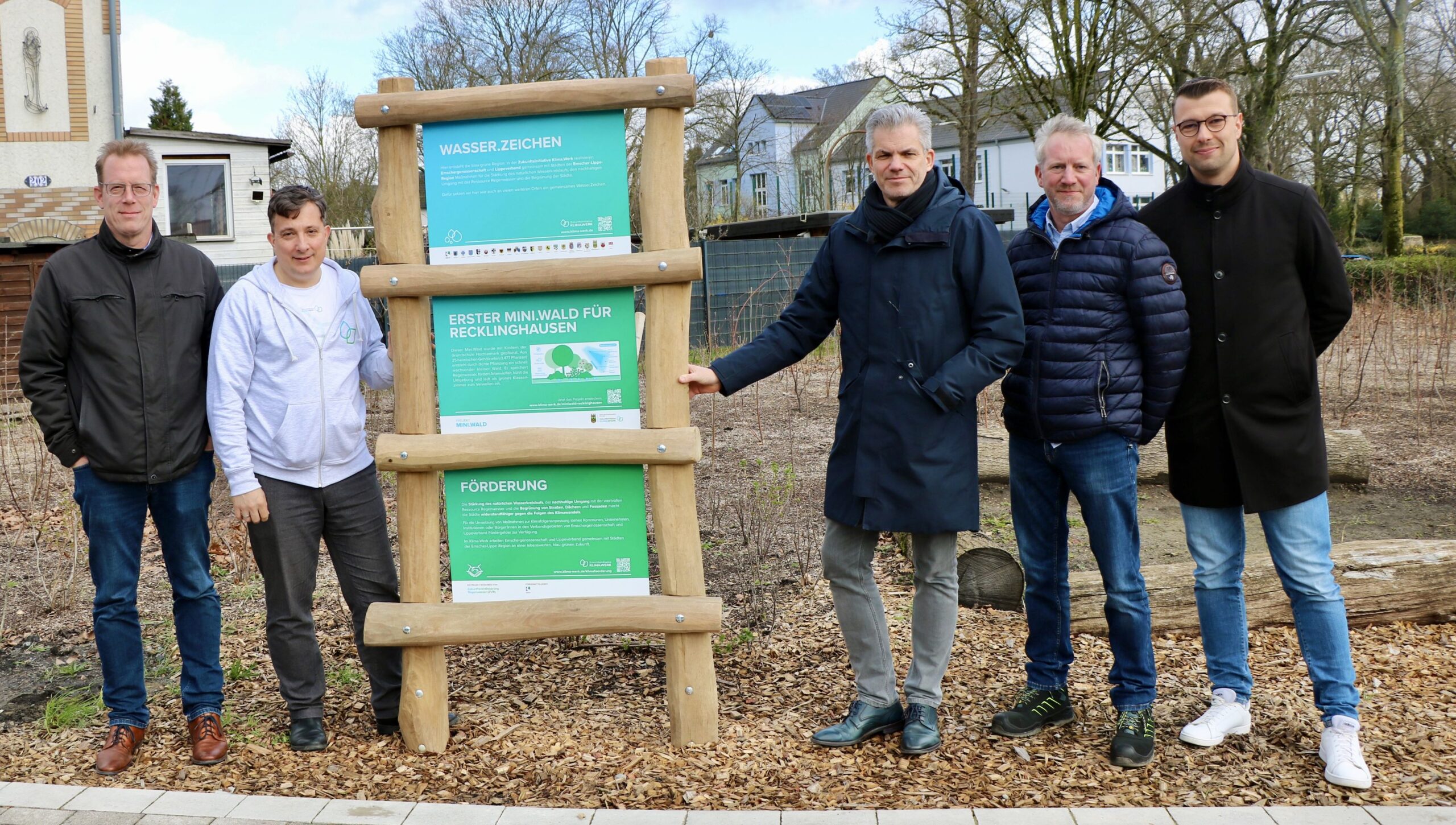 Gruppe von Beiteilten um eine Stehle des Wasser-Zeichens:(v.li.): Stefan Frackowiak (Abteilungsleiter Klima, Umwelt, Nachhaltigkeit und Stadtgrün bei der Stadt RE), Andreas Giga, (Leiter der Serviceorganisation der Zukunftsinitiative Klima.Werk bei Emschergenossenschaft/Lippeverband), Dezernent Axel Fritz, Michael Godde (Straßenbau Stadt RE) und Klimaanpassungsmanager Felix Sprenger.